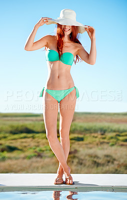 Buy stock photo Hat, bikini and woman by swimming pool in nature outdoor for vacation, holiday or summer travel in the countryside by blue sky. Redhead, smile and young person happy in swimsuit, beauty and body