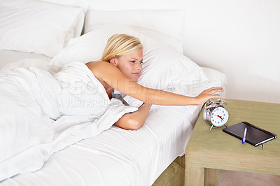 Buy stock photo Snooze, alarm and woman wake up with clock in morning and tired on bed in home with stress, fatigue and lazy. Angry, girl and press stop or time to start day and frustrated with routine in bedroom