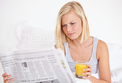 Buy stock photo Young woman, worry or orange juice with newspaper on bed, frustrated or drink for health body in wellness. Blonde model, headlines or glass of fruit smoothie to detox, morning or vitamin c in bedroom