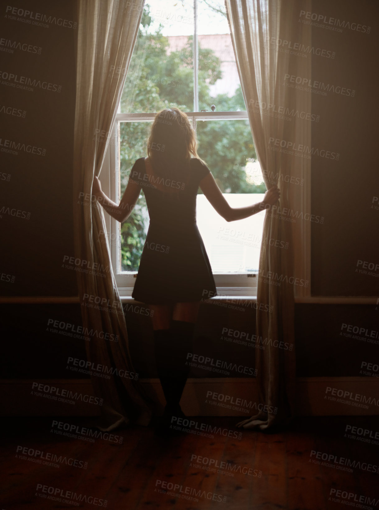 Buy stock photo Woman, curtain and morning by window for sunlight, vitamin D or sunshine in bedroom at home. Rear view of female person standing by blinds or glass in casual clothing and looking out in neighborhood