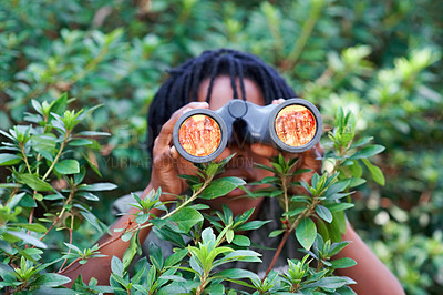 Buy stock photo Boy, kid and binoculars for search in nature while learning and fun in forest or adventure at summer camp. Young African child, green leaves and explore environment outdoor with youth and discovery