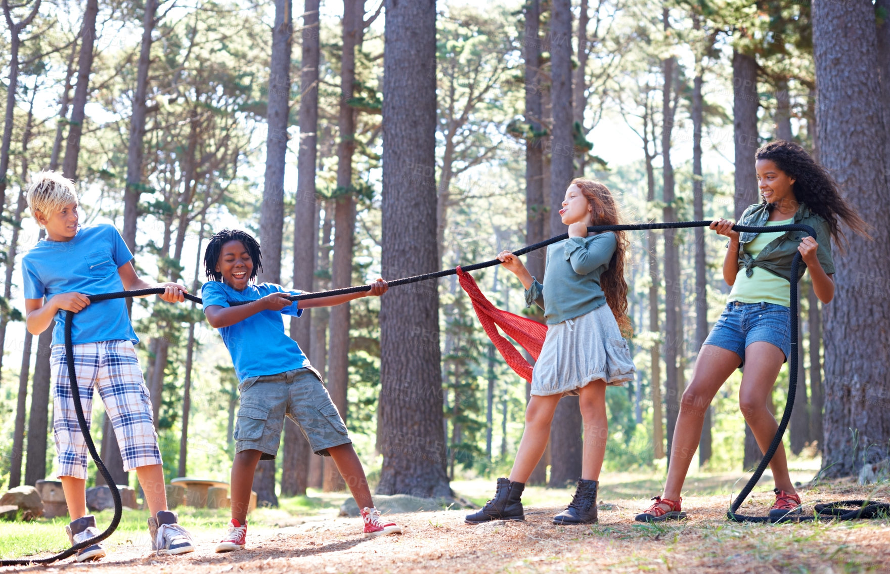 Buy stock photo Kids, rope and tug of war for play adventure, challenge and strength game in woods with summer camping. Children, diversity and competitive in forest environment and teamwork in power match by trees
