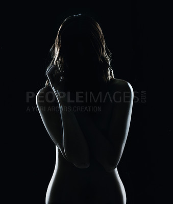 Buy stock photo Silhouette of a naked young woman against a dark bakground