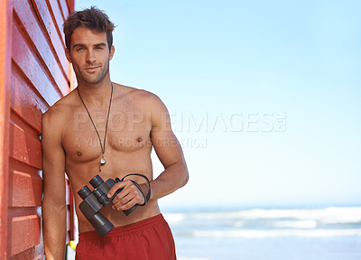 Buy stock photo A handsome young lifeguard at the beach