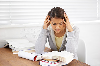 Buy stock photo Shot of an attractive young college student battling with her studies