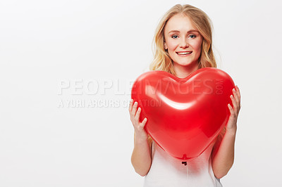 Buy stock photo Cropped view of a young woman holding a red heart in a studio