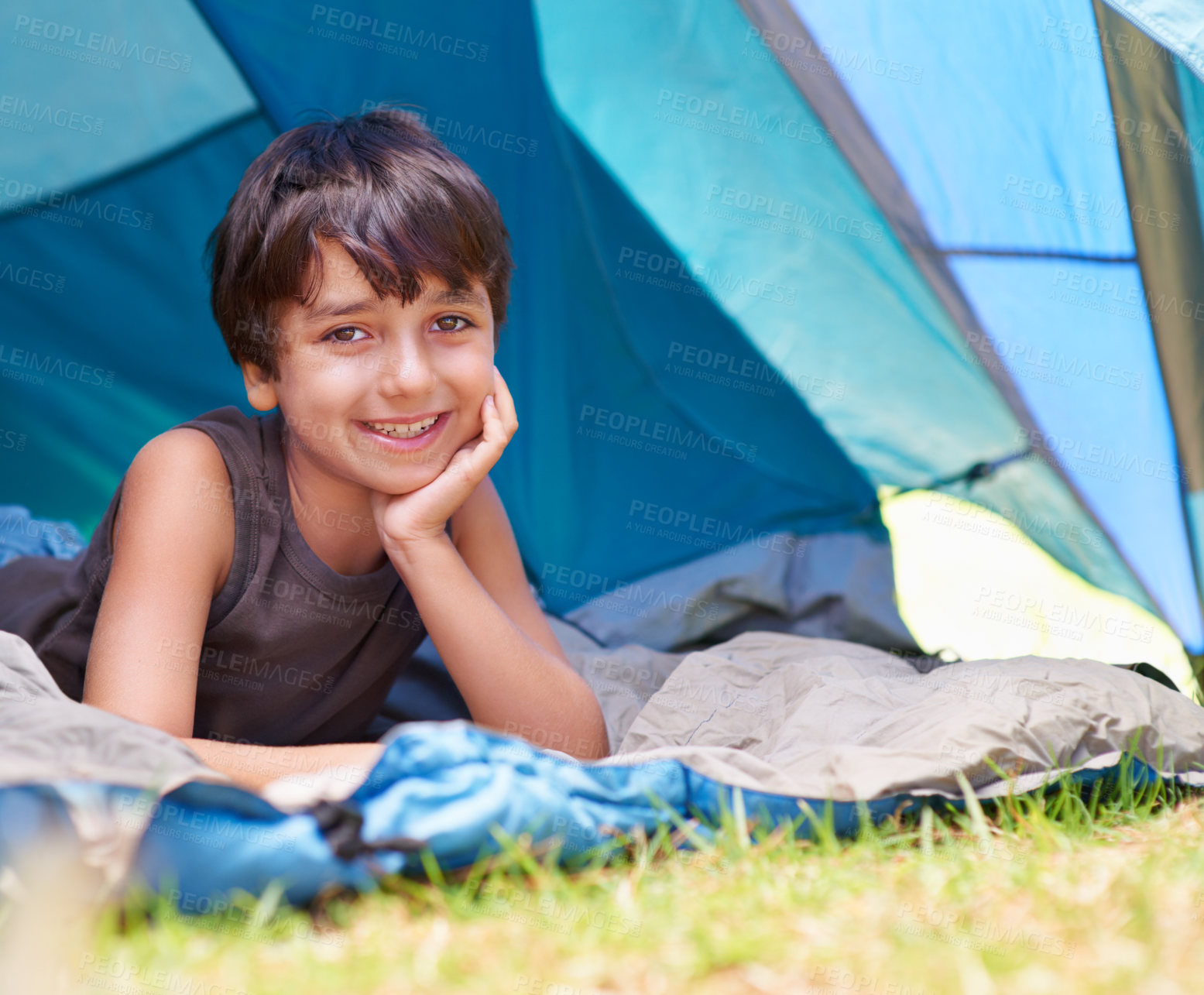 Buy stock photo Boy, kid and camping, relax in tent and summer vacation with travel and happy in portrait outdoor. Rest on sleeping bag, young child with smile and adventure in nature, childhood and recreation