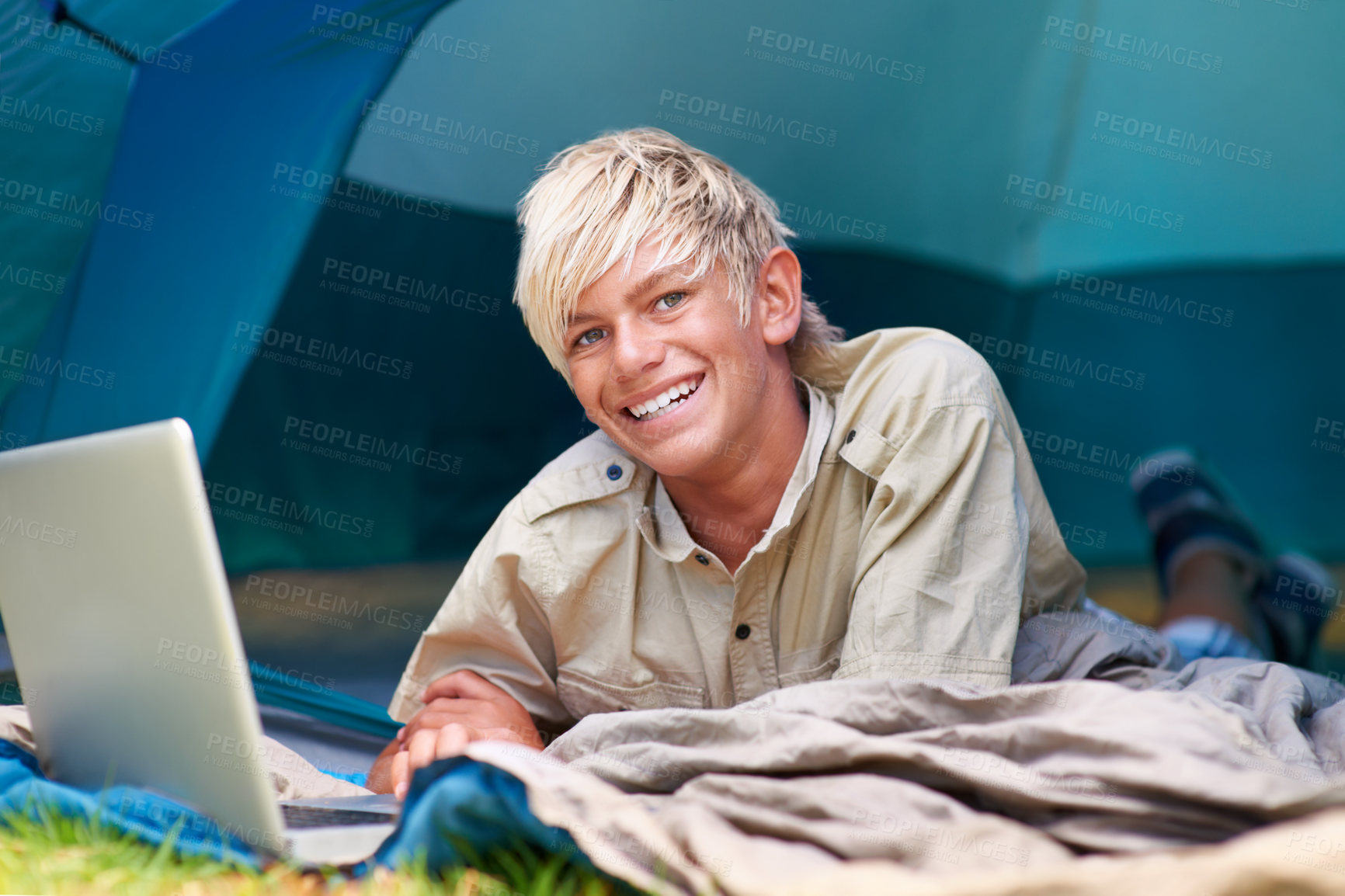 Buy stock photo Child, boy and happy with laptop in tent for camping, social media and online movie with portrait in nature. Person, face and kid with smile outdoor on grass for gaming, vacation and holiday fun