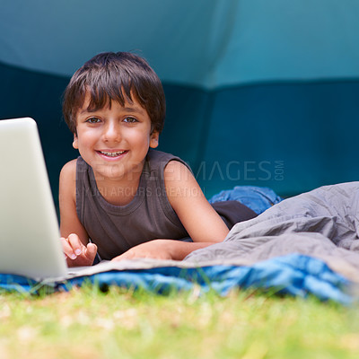 Buy stock photo Child, boy and smile with laptop in tent for camping, social media and online movie with portrait in nature. Person, face and kid or happy outdoor on grass for gaming, vacation relax or holiday fun