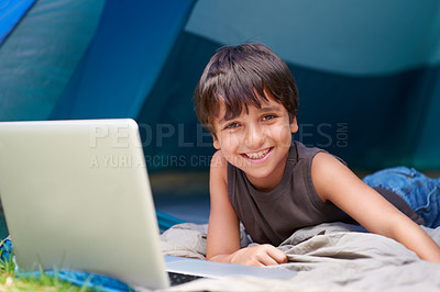 Buy stock photo Kid, boy and happy with laptop in tent for camping, social media and online movie with portrait in nature. Person, face and child with smile outdoor on grass for gaming, vacation relax or holiday fun