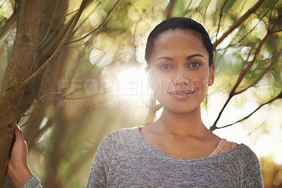 Buy stock photo Portrait of a confident young woman standing with her arms folded outdoors