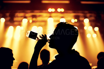 Buy stock photo Night, club and man with a drink at party, event or music festival with stage lights and silhouette. Dark, concert and person dance with bottle of alcohol in crowd at social celebration or rave