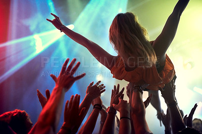 Buy stock photo Concert, music festival and a woman crowd surfing at a club with lights and people in celebration. Group of men and women or fans at a rock or social event or show for live performance at a nightclub