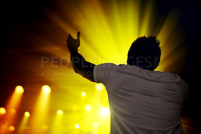 Buy stock photo Music, concert and man in celebration at night, event or cheering with lights from stage. Dark, festival and back of person with energy at nightclub or dancing at show with lighting and shadow