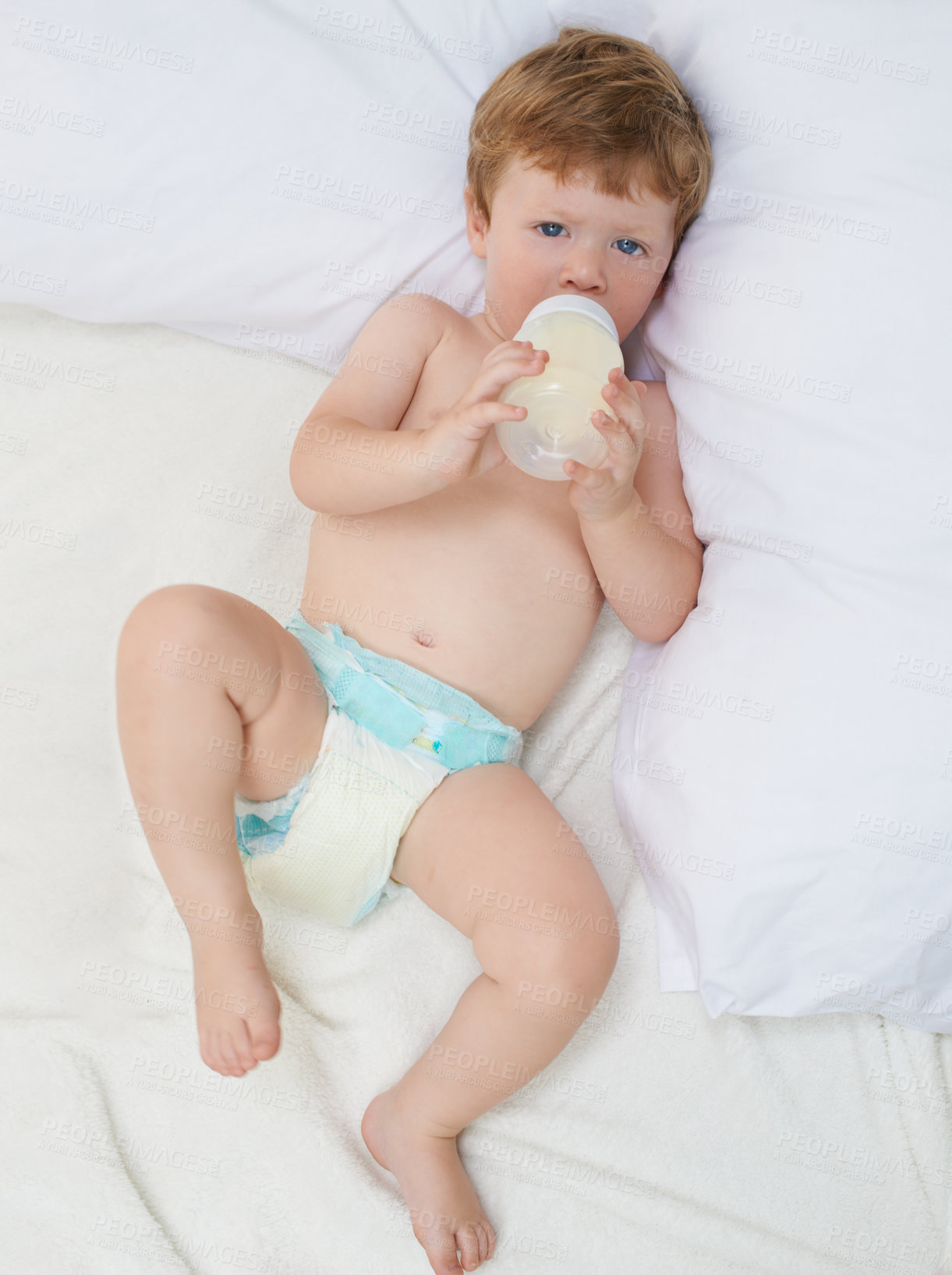 Buy stock photo Full length shot of a sweet little baby lying down drinking a bottle of formula