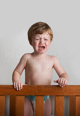 Buy stock photo Sad toddler, crying and portrait of baby in his crib or home with emotional anger or loss in childhood. Problem, trouble and house with a frustrated young male kid, infant or boy with tears or noise