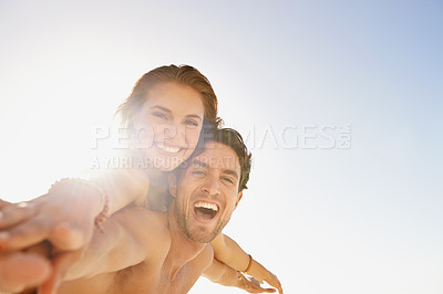 Buy stock photo Happy couple, portrait and piggyback in support with blue sky at beach in love, care or enjoying outdoor holiday weekend. Face of man and woman smile for fun embrace, trust or hug in summer on mockup