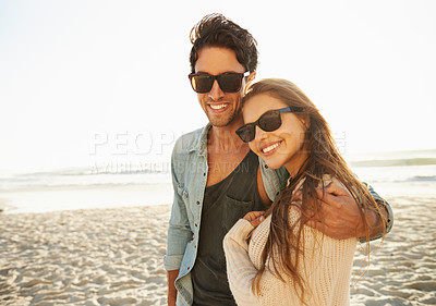 Buy stock photo Portrait of a loving young couple standing and holding each other on the beach