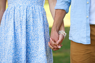Buy stock photo Cropped shot of a young couple holding hands outside