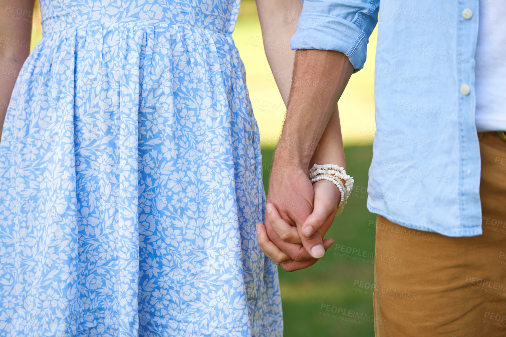 Buy stock photo Cropped shot of a young couple holding hands outside