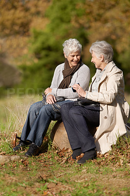 Buy stock photo Senior women, laughing or conversation in nature for travel, together or bonding on retirement in outdoor. Elderly friends, smile or communication on vacation in countryside, care or social on rock