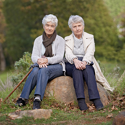 Buy stock photo Senior friends, portrait or outdoor in nature on rock, together or bonding on retirement on holiday. Elderly women, serious or face on trip in countryside, winter or care for person with disability