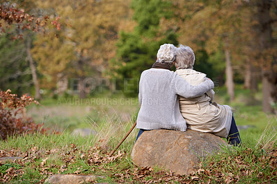 Buy stock photo Rear view of two senior women sitting on a rock together