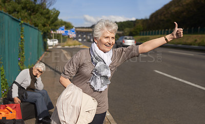 Buy stock photo Women, road and hitch hiker for lift in retirement, travel and friends in city with bags for adventure. Senior ladies, thumbs up and happy by roadside with hand gesture and stop transport to commute