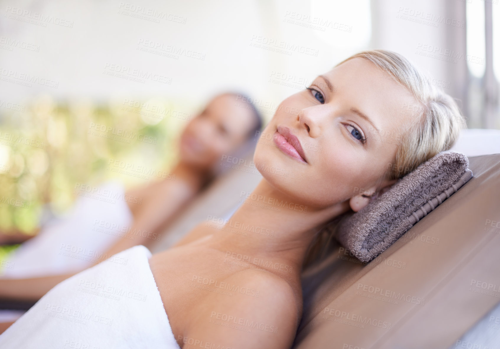 Buy stock photo A gorgeous blond woman looking at you while lying on a spa bed