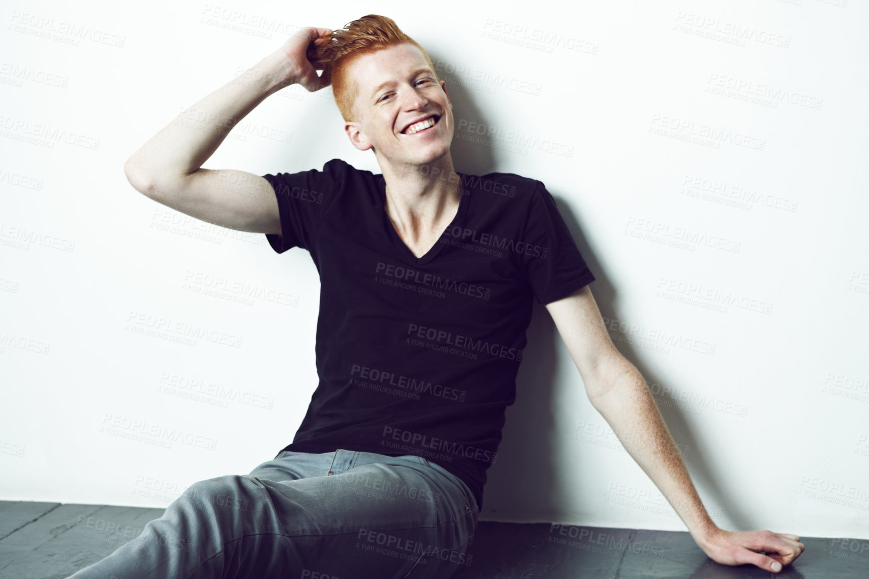 Buy stock photo Portrait, ginger and man sitting on a floor with hand on head or relax or smile for fashion and against white wall. Happy, unique style and excited male model with red hair laugh for fun in studio