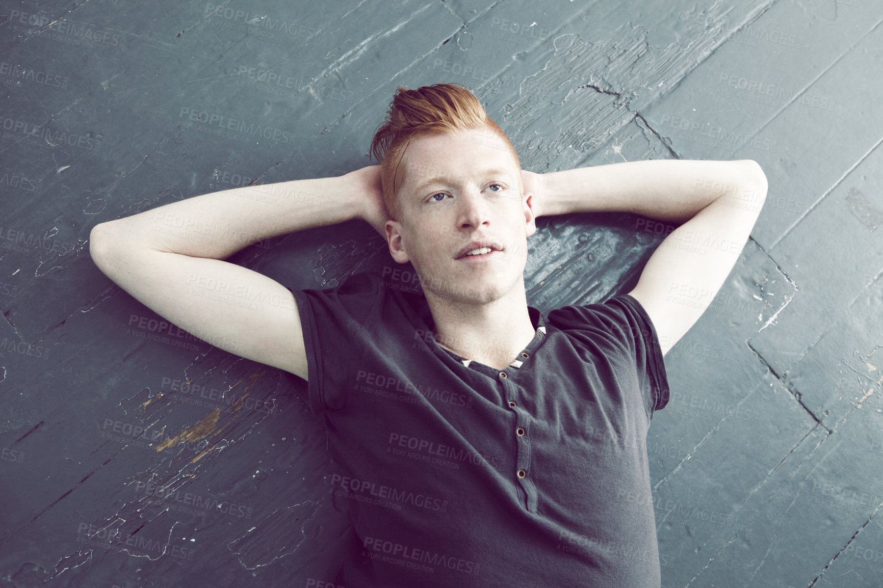 Buy stock photo A red haired male lying on the floor and looking upwards with a thoughtful look on his face