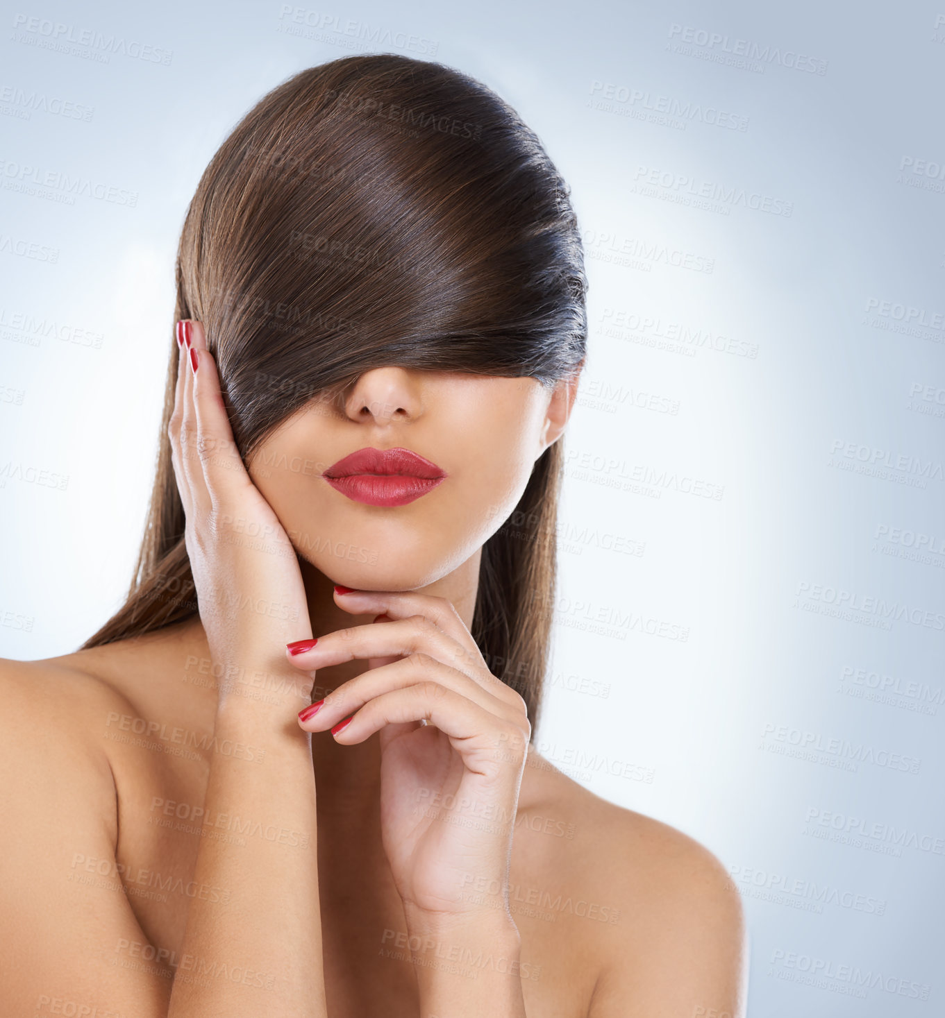 Buy stock photo Studio shot of a young woman covering her eyes with her hair