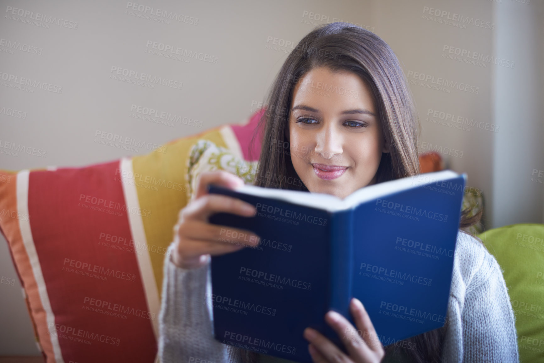 Buy stock photo Cropped view of a young woman enjoying a good book