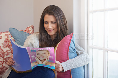 Buy stock photo Woman, beauty magazine or reading book in home for skincare tips, knowledge or press news to relax. Female person, smile or information for learning, fun gossip story or resting on chair on weekend