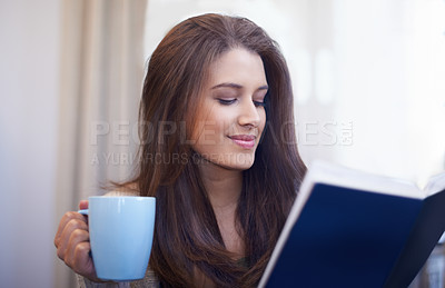 Buy stock photo Woman, drinking coffee and reading book to relax at home, literature and fiction novel for knowledge. Female person, happy and information for learning, comfortable and fantasy story on weekend