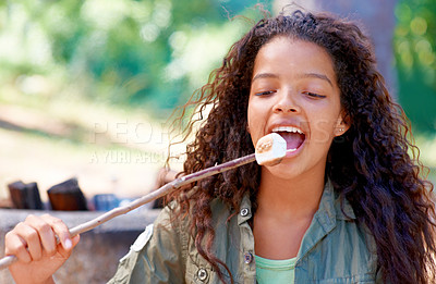 Buy stock photo A young girl biting a fireside treat