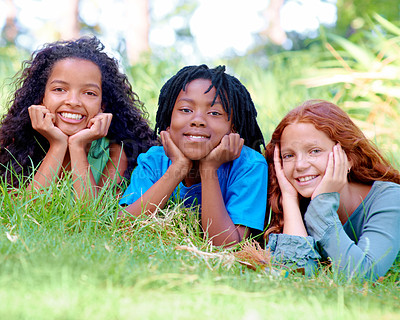 Buy stock photo Nature, smile and portrait of kids on grass in outdoor park, field or garden together. Happy, diversity and group of excited young children relaxing and laying on lawn in woods or forest for summer.