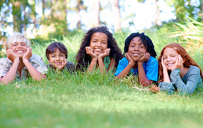 Buy stock photo Nature, smile and portrait of children on grass in outdoor park, field or garden together. Happy, diversity and group of excited young kids relaxing and laying on lawn in woods or forest for summer.