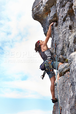 Buy stock photo Rock climbing, fitness and blue sky with woman on mountain for adventure, travel and explore. Strong, freedom and cliff with female climber training in nature for courage, safety and workout