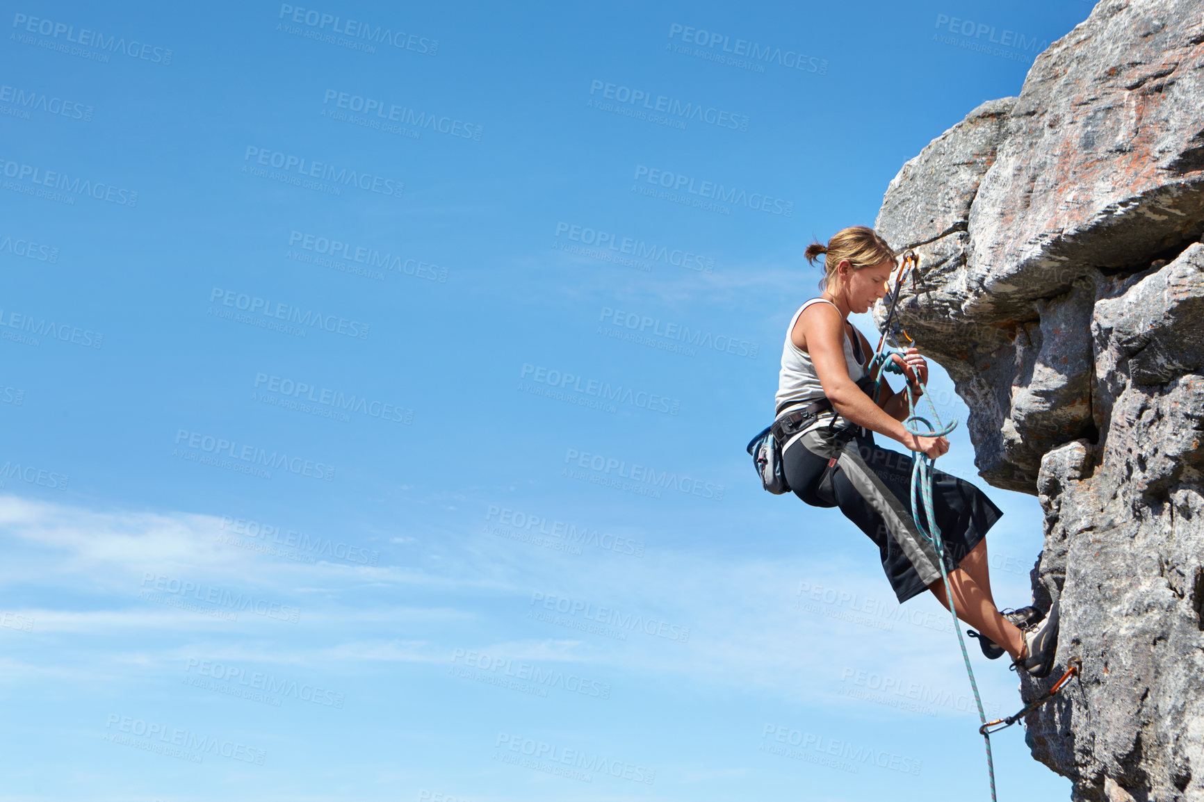 Buy stock photo Rock climbing, blue sky and freedom with woman on mountain cliff for adventure or travel with space. Strong, challenge and mockup with female climber training in nature for courage, safety or workout