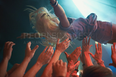 Buy stock photo A young woman crowd-surfing at a concert
