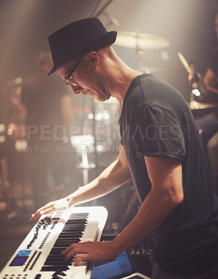 Buy stock photo Concert, musician and man on piano at stage for performance, rock band or audio at music festival. Artist, professional or play on electric keyboard, synthesizer instrument or sound for entertainment