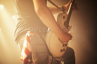 Buy stock photo A guitarist performing a sick solo while rocking out with his band at a jam-packed gig