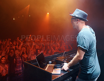 Buy stock photo Shot of a young deejay entertaining the crowd at a concert. This concert was created for the sole purpose of this photo shoot, featuring 300 models and 3 live bands. All people in this shoot are model released.