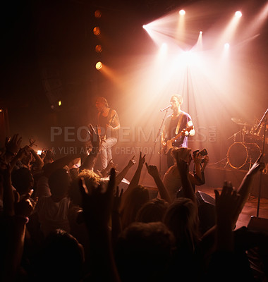 Buy stock photo Rear view of an excited crowd cheering their favourite band on beneath the strobe lights at a festival