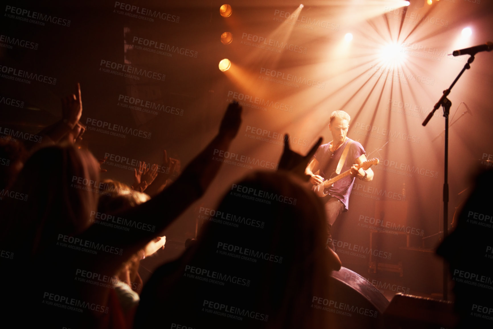 Buy stock photo Rear view of an excited crowd cheering their favourite band on beneath the strobe lights at a festival. This concert was created for the sole purpose of this photo shoot, featuring 300 models and 3 live bands. All people in this shoot are model released.
