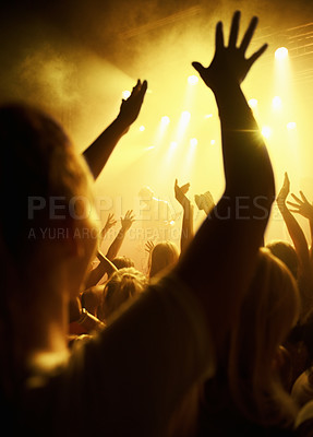 Buy stock photo Rearview of fans dancing with their hands in the air at a rock concert. This concert was created for the sole purpose of this photo shoot, featuring 300 models and 3 live bands. All people in this shoot are model released.