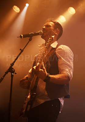 Buy stock photo Concert, singer and guitar with man on stage for music, performance and rock show. Event, spotlight and energy with male musician playing instrument at festival club for rave, disco and celebration