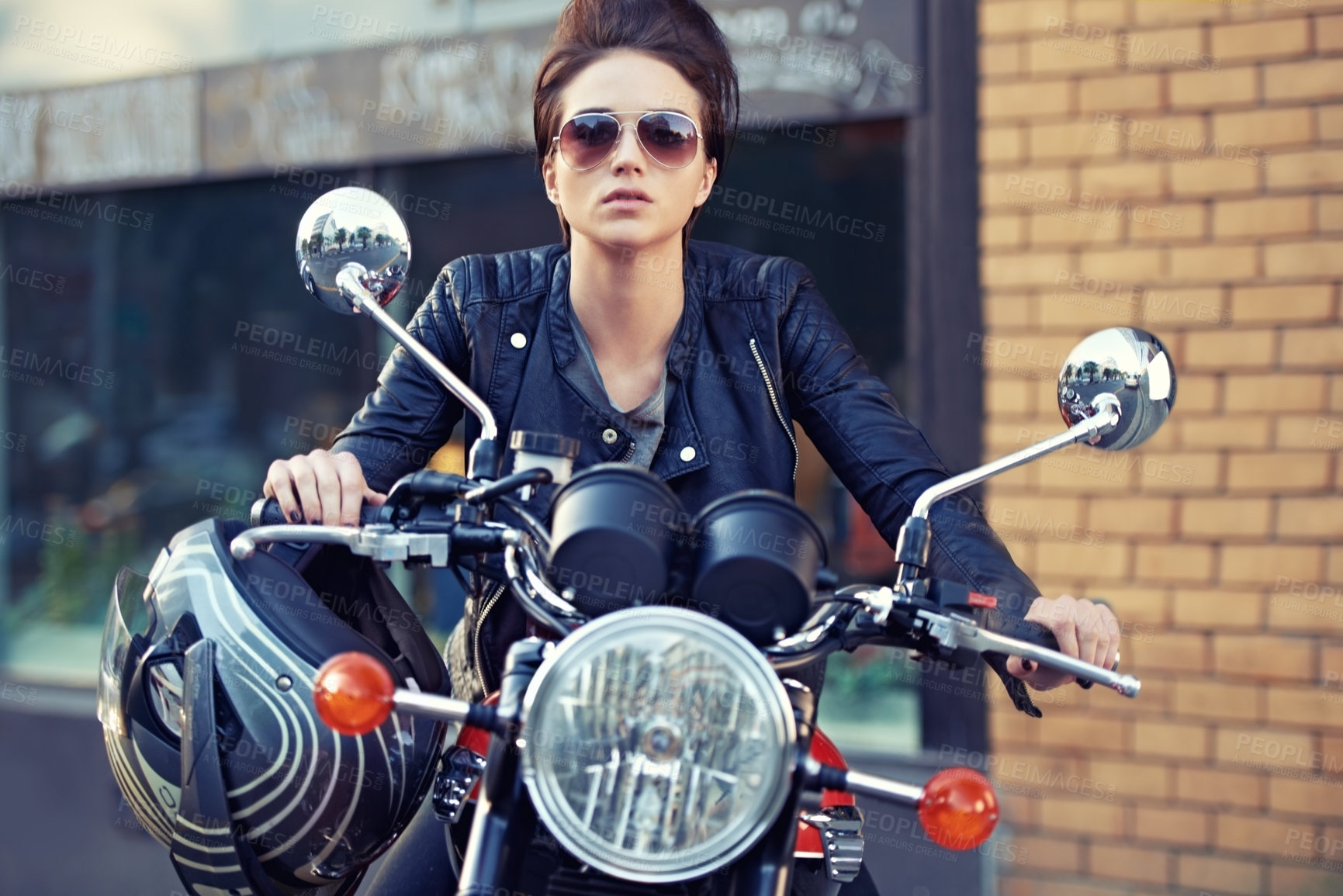 Buy stock photo Shot of a young and stylish female motorcycle rider outside