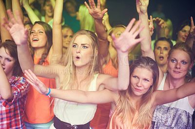 Buy stock photo Women, hands up and dancing at music festival, live band performance and techno rave party in nightclub, concert and disco. Friends, crowd and audience on dance floor in show, freedom or energy event